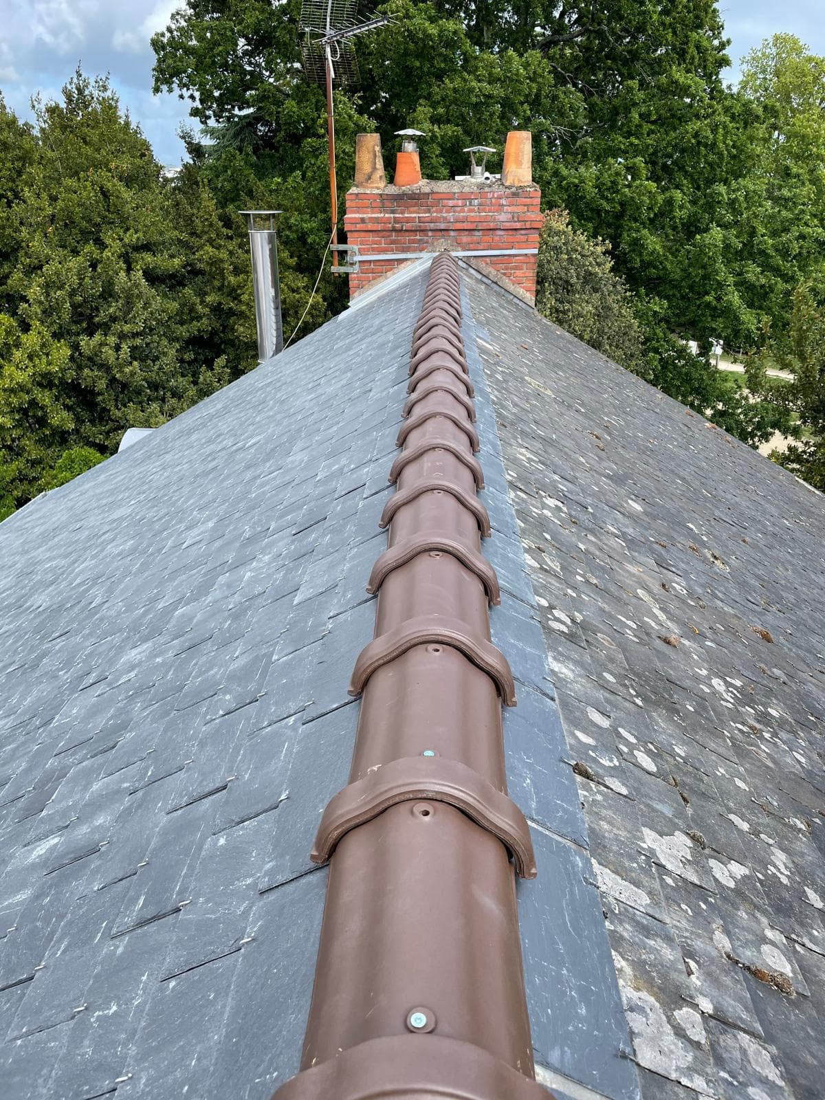 Ouvrage de zinguerie au sommet d’une toiture en pente